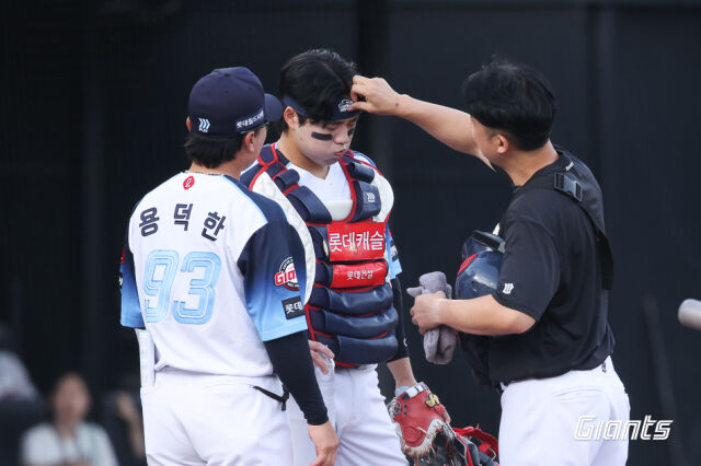 롯데 자이언츠 포수 손성빈이 31일 사직구장에서 열린 삼성 라이온즈와 홈 경기 2회초 수비 도중 두통 증상을 호소해 유강남과 교체됐다. 용덕한 배터리코치와 트레이너가 손성빈이 몸상태를 살피고 있다./롯데 자이언츠 제공