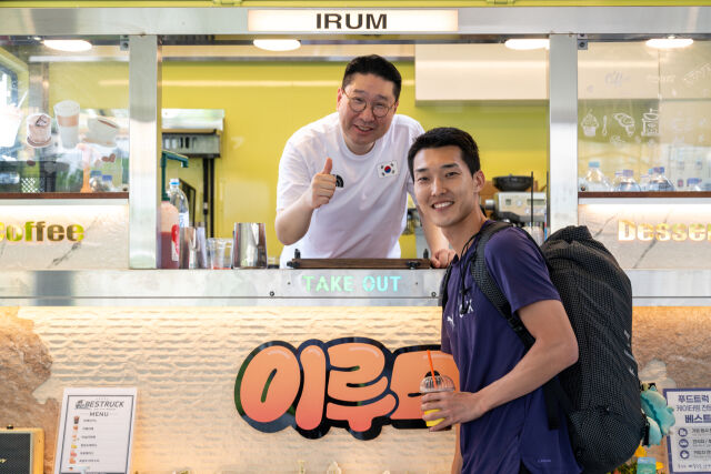높이 뛰기 우상혁(오른쪽)에게 커피를 전해주는 이상현 단장. /대한체육회 제공