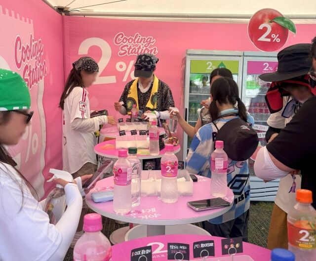 2% 부족할 때 쿨링 스테이션에서 관객이 음료를 시음하고 타투 스티커 체험에 참여하고 있다. /롯데칠성음료