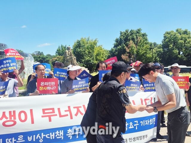 기자회견을 마치고 한국수퍼마켓협동조합연합회 관계자들이 관계자에게 골목상권 비상대책 촉구와 대통령 면담 요청서를 전달하고 있다. /방금숙 기자