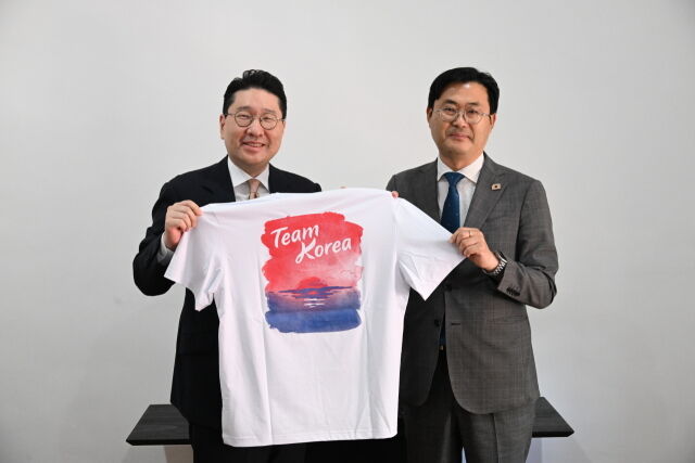 이상현 단장(왼쪽)이 이정문 국회의원에게 대한민국 선수단 티셔츠를 전달하고 기념 촬영을 하고 있다. /대한체육회 제공