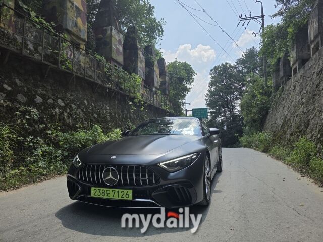 유려한 곡선 위로 AMG 전용 라디에이터 그릴의 14개 수직 슬랫이 이빨처럼 늘어서 있고, 길고 평평한 보닛에는 두 개의 파워 벌지가 솟아 있다. 상어 한 마리가 이빨을 드러낸 채 수면 바로 아래에서 다가오는 듯한 모습이다. /윤진웅 기자