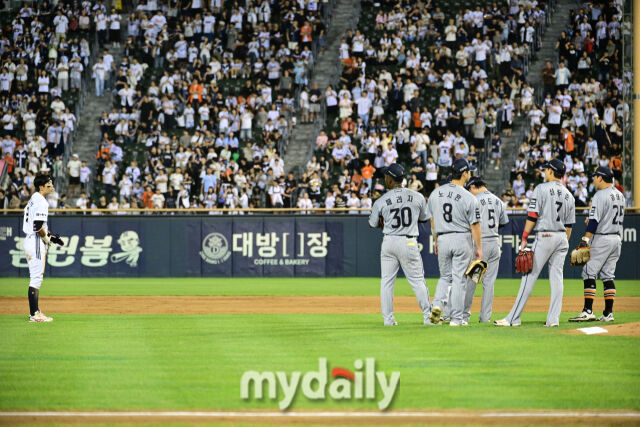 비디오 판독을 기다리는 한화 선수들과 두산 김민석.