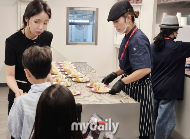 직원들이 투어 참가자들에게 만두와 멕시칸 냉동치킨 시식 제품을 나눠주고 있다. /방금숙 기자