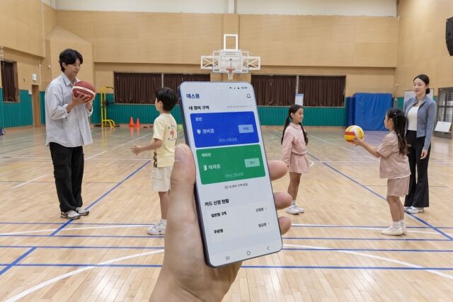 에스원 학교 안전 솔루션이 적용된 체육관 내부 상황을 모바일 앱으로 모니터링하고 있다. /에스원