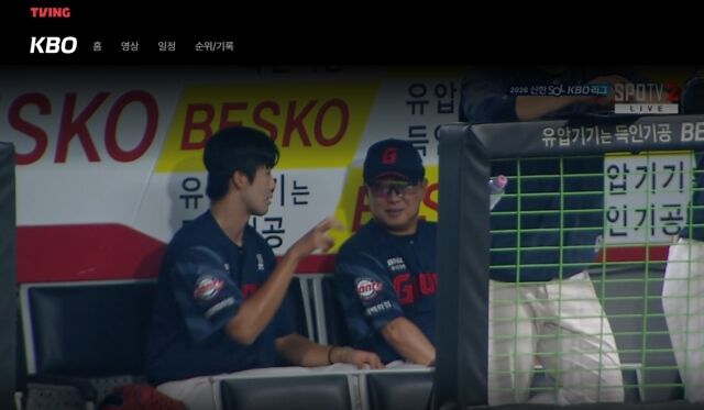 롯데 자이언츠 김태형 감독이 26일 광주 KIA챔피언스필드에서 열린 KIA 타이거즈와의 원정경기 도중 김한결의 얘기를 듣고 웃고 있다./티빙 캡쳐