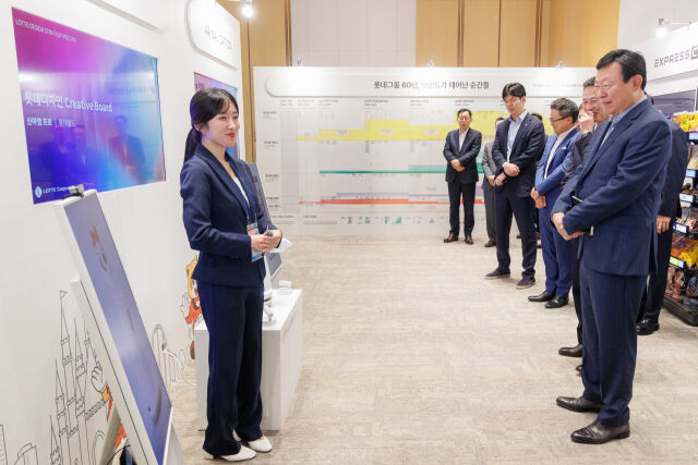 롯데는 10일 롯데월드타워에서 '2026 롯데 디자인전략회의'를 개최했다. 신동빈 롯데 회장(오른쪽 첫번째)이 젊은 디자이너들의 AI 프로젝트 결과물인 '로티로리 로봇 롯데월드 안내 서비스'에 대한 설명을 듣고 있다. /롯데