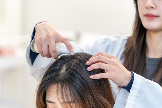 한국콜마 연구원이 두피 전용 자외선 차단제를 테스트하는 모습. /한국콜마