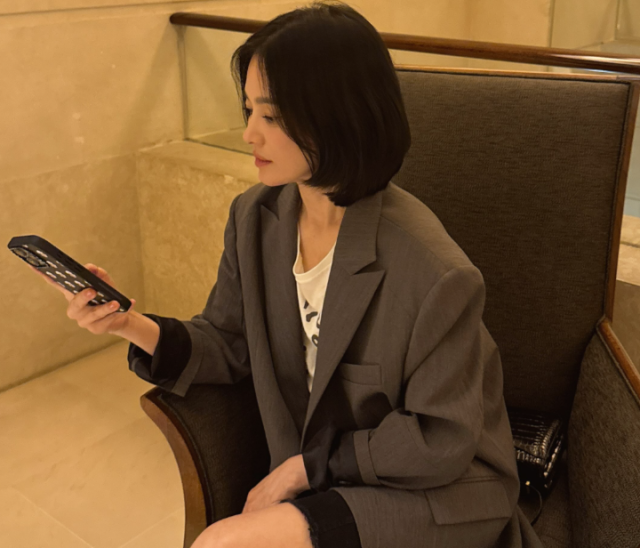 핸드폰을 보고 있는 송혜교는 단정하면서도 시크한 단발머리 스타일을 완벽하게 소화하며 인형을 연상시키는 이목구비를 자랑했다./송혜교 소셜미디어