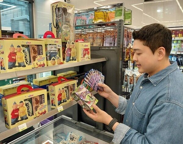 CU에서 모델이 포켓몬 카드팩을 보고 있다. /BGF리테일