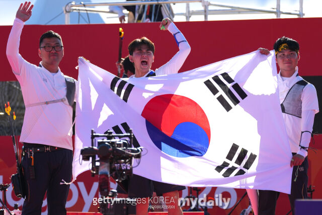 한국 남자 양궁 대표팀이 2일 2026 아이치·나고야 아시안게임 양궁 리커브 남자 단체전에서 인도를 꺾고 금메달을 따낸 뒤 태극기를 들고 기뻐하고 있다./게티이미지코리아