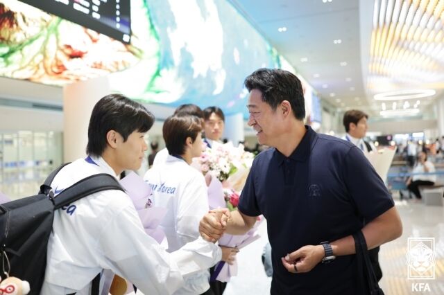 최우진(왼쪽)이 2026년 10월 4일 인천국제공항을 통해 귀국한 뒤 이민성 대한민국 남자 축구대표팀 감독과 인사하고 있다./대한축구협회 제공