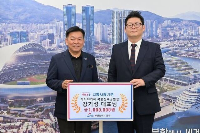 ‘상어 특수’를 누린 강기성 이디야커피 북항친수공원점 대표(오른쪽)가 고향사랑기부금을 전달한 뒤 강철호 동구청장과 기념사진을 찍고 있다. /부산 동구