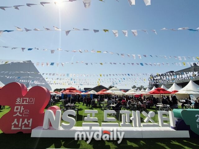 ‘NS푸드페스타’ 조형물이 서 있는 야외 광장에서 관람객들이 음식을 먹으며 축제를 즐기고 있다. /방금숙 기자