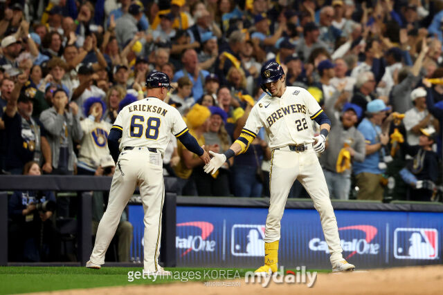 MLB 밀워키에서 뛰고 있는 크리스티안 옐리치(오른쪽)가 24일(한국시각) 열린 탬파베이와 2026 월드시리즈 1차전 1회말 선취점을 이끌어 낸 적시 3루타를 친 뒤 3루 베이스에서 코치와 하이파이브를 하고 있다./게티이미지코리아