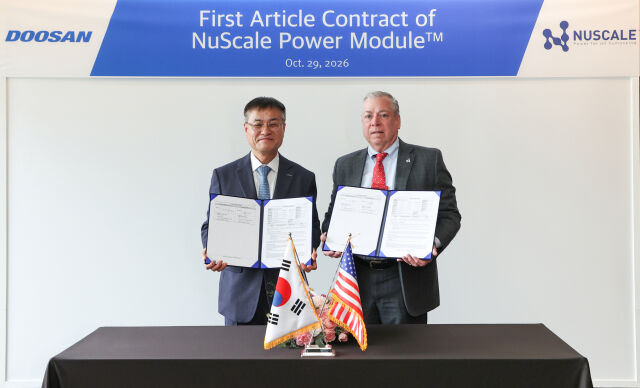 29일 창원 본사에서 열린 계약 체결식에서 뉴스케일파워 칼 피셔 COO(사진 오른쪽)와 두산에너빌리티 김종두 사장이 기념 촬영하고 있다. /두산에너빌리티